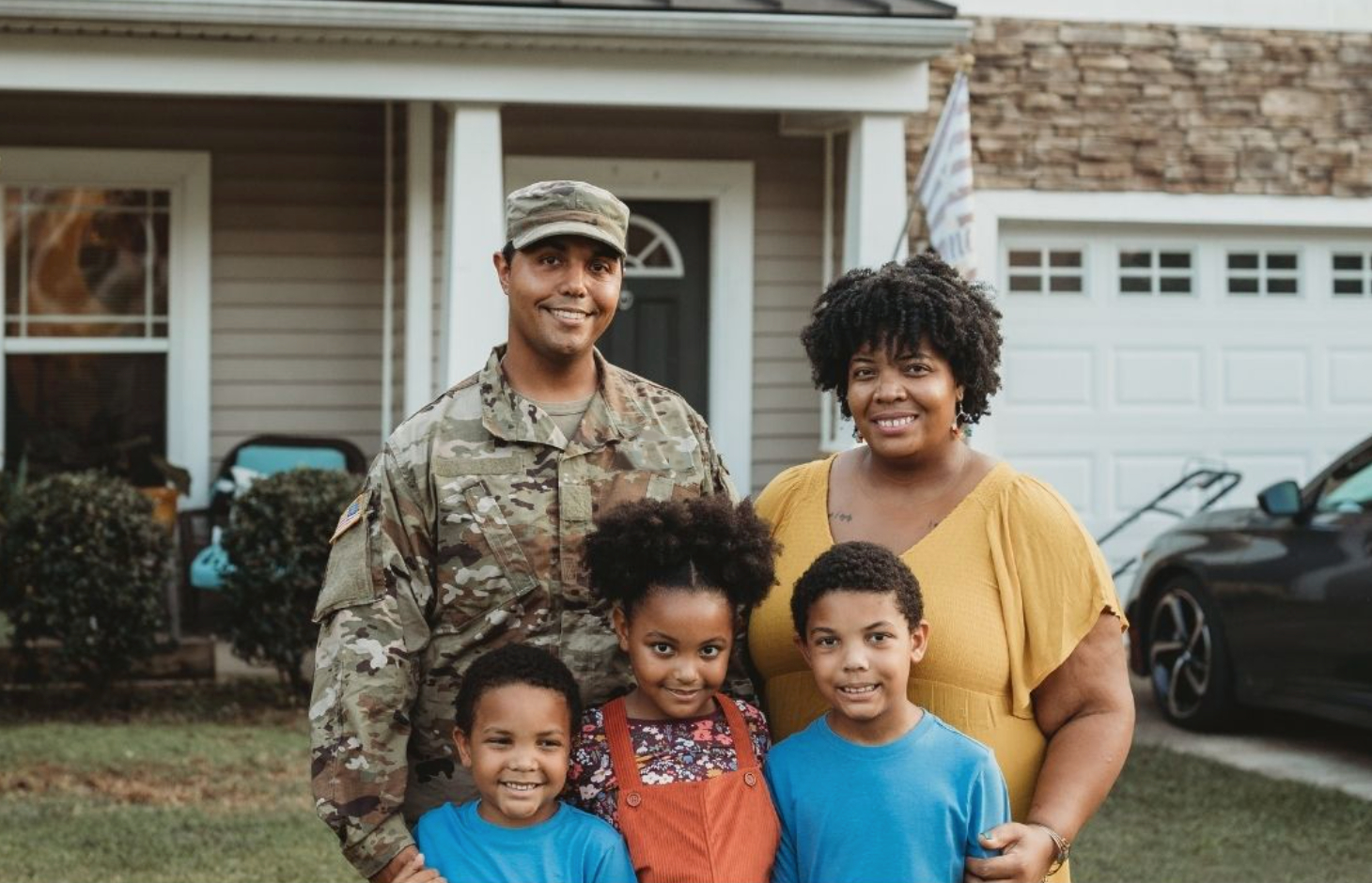 Service Member and family infront of house