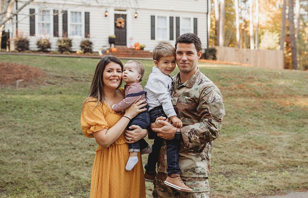 Service Member and family infront of house
