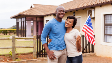 Arthur and his wife holding American flag.