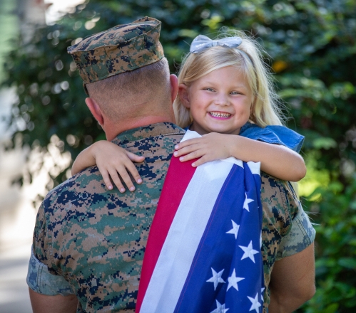 Service member with daughter holding US flag
